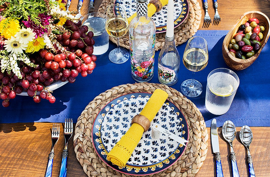 A balance of warm and cool hues enlivens the table, which is grounded in earthy materials such as wood and natural fibers.
