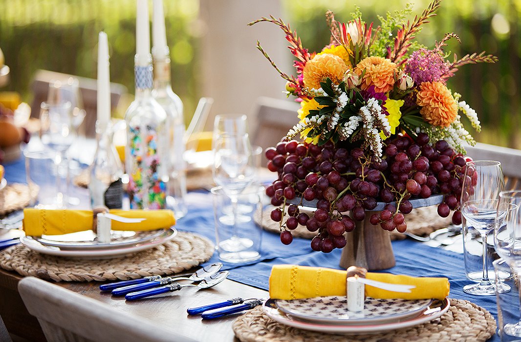 A cake stand, a vase of flowers, and a few bunches of grapes are all you need to recreate this abundant arrangement.
