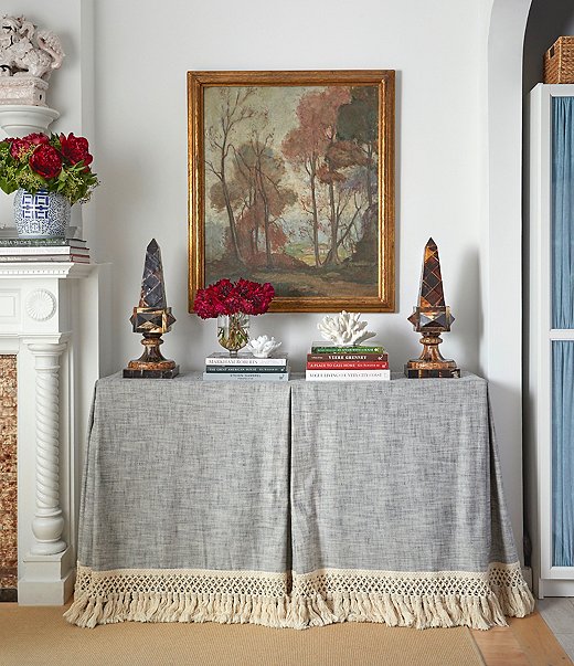 The living room’s elegant console (actually an Ikea table upgraded with a custom skirt) is a secret storage powerhouse, concealing bedding, towels, table linens, and off-season textiles. Books, objets, and a painting found at the Brimfield Antique Show make up an artful vignette on top, creating that layered feel that Lilse loves. “My entire look veers toward lived-in and collected,” she says.
