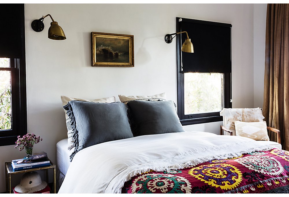 A step up from the air mattress the couple used to have for visitors, the guest bedroom features a vintage suzani blanket and Atelier de Troupe sconces.
