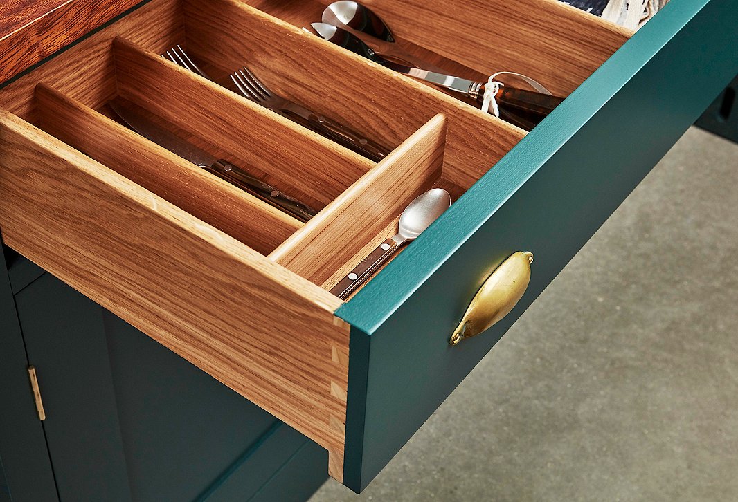 Dovetail joints, classic brass hardware, and hand-painted finishes give this Plain English kitchen a timeless feel. The divided drawer makes it easy to organize flatware and other kitchen accessories.
