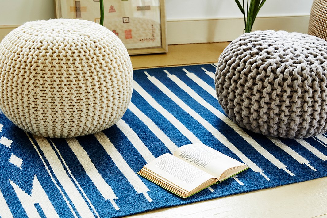 Top a soft flat-weave rug with a knit pouf or two to create a spot where everyone can get comfortable.
 
 
