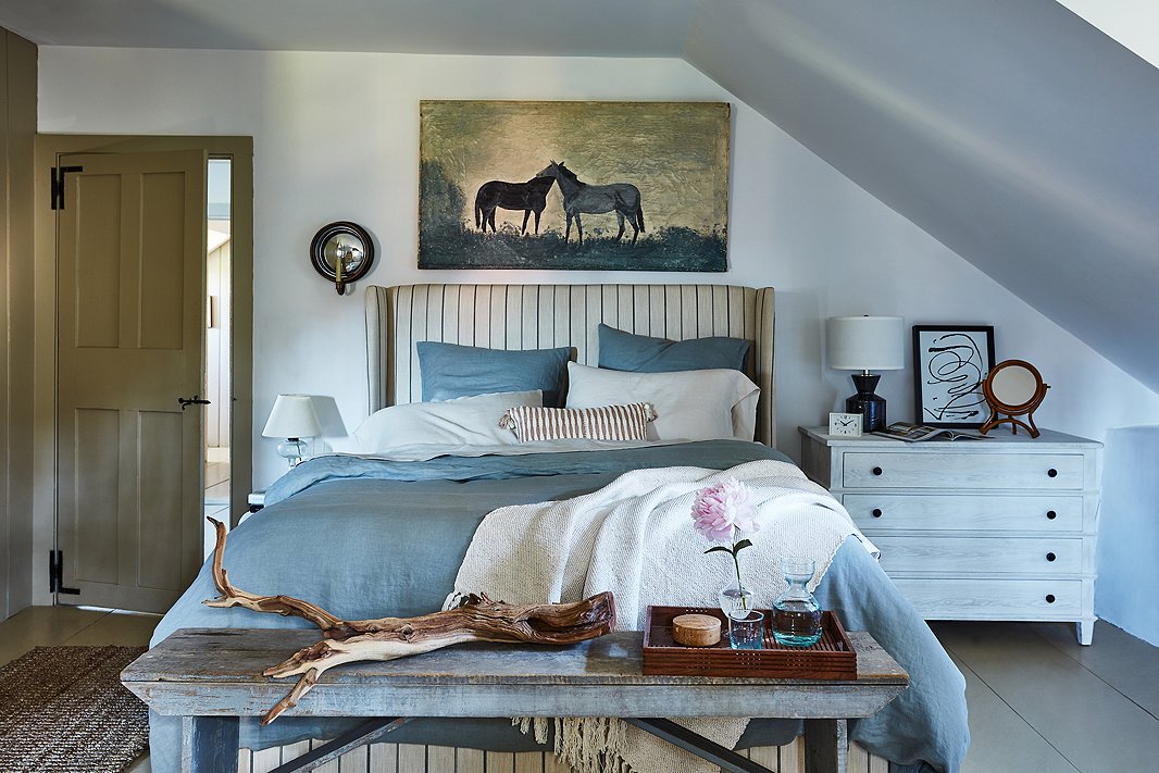 The classic combo of blue and white becomes warmer and more relaxed when softened by dashes of off-white (the striped tan bed, for instance). Seemingly nonchalant asymmetry adds to the laid-back look.
