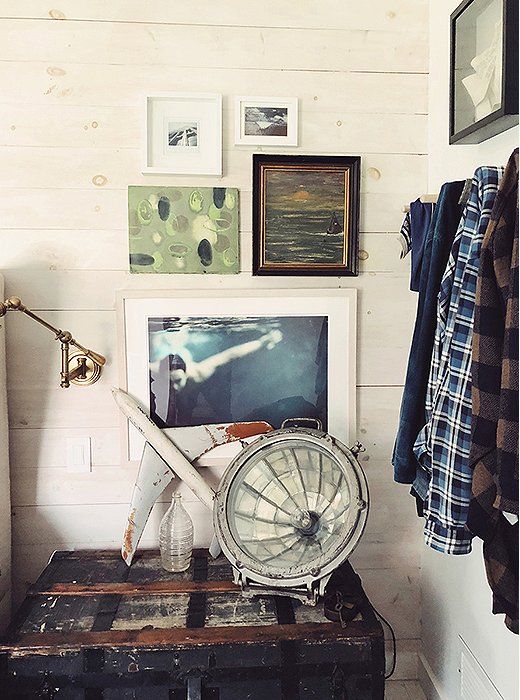 Next to the bed, a mixed-media gallery wall anchors a charmingly weathered vignette. A vintage trunk steps in as a side table (and adds welcome storage to the small space).
