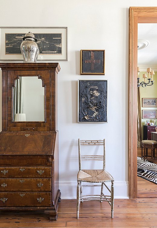 A trio of framed artworks around an antique secretary makes for an intriguing vignette.
