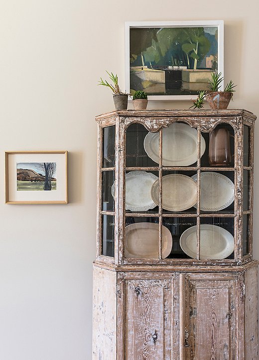 A vintage armoire with a beautifully weathered patina displays Chad’s collection of porcelain platters.
