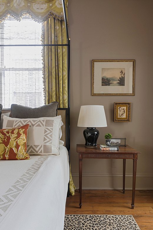 A crisp white coverlet contrasts with the rich tones of the master bedroom, creating a fresh yet enveloping atmosphere.

