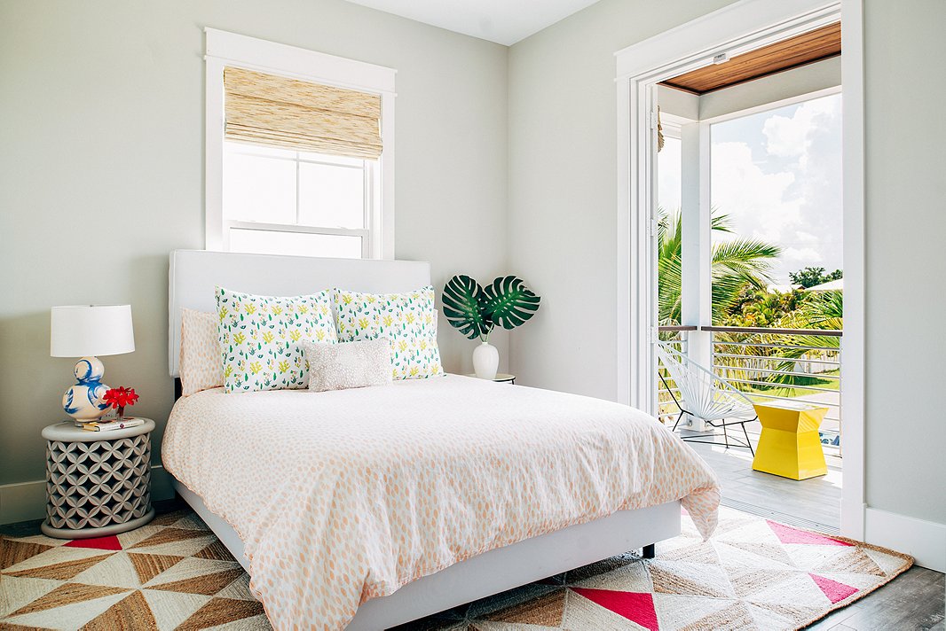 The clients often open up their home to friends and family, so this light-filled guest bedroom sees frequent use. The pops of pink in the geometric rug liven up the soft gray walls.
