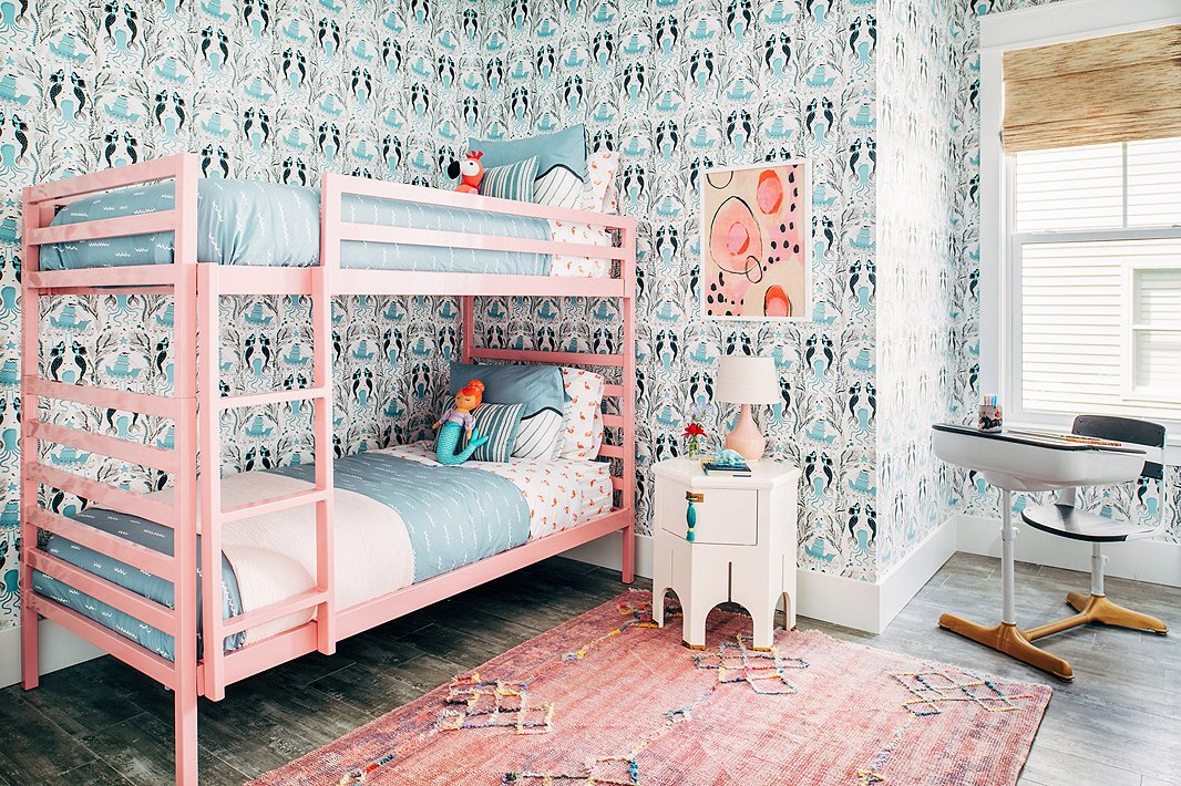 From the vintage rug to the Moroccan-inspired side table to the abstract artwork, this girls’ room is anything but juvenile. The pink bunk bed? Pure fun.
