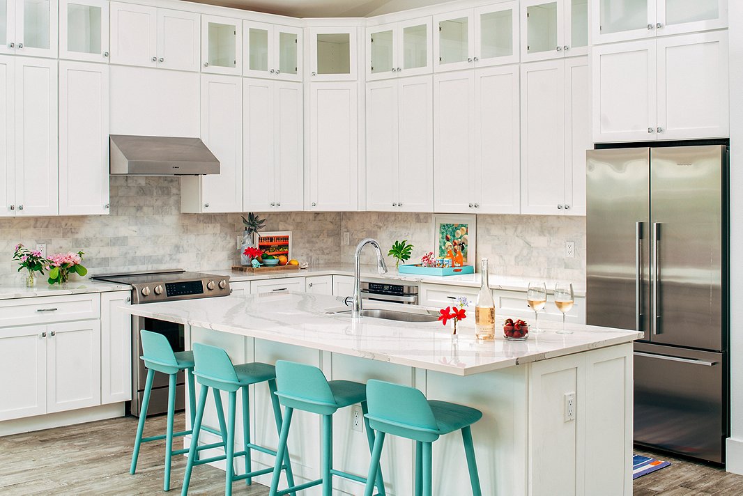 Light, bright, and airy: Everything you want in a beach-house kitchen. A row of turquoise barstools offers the perfect spot for post-pool lunch.
