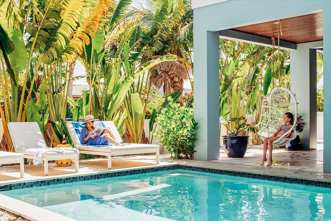 Towering palms, plush lounge chairs, and a seaside palette feel right at home on this Florida patio. Photo by Seamus Peane, courtesy of Hannah Crowell. 
