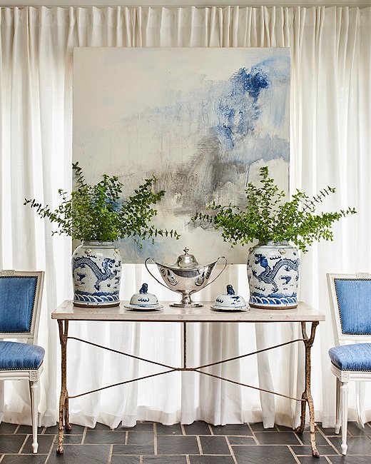 A painting by Kelley Estes picks up on the dining room’s cool blue color scheme. “I love mixing contemporary and abstract art into interiors,” says Minnette. “The right piece can add a much-needed dose of color, form, and contrast that can keep a room from feeling too predictable or stuffy.”
