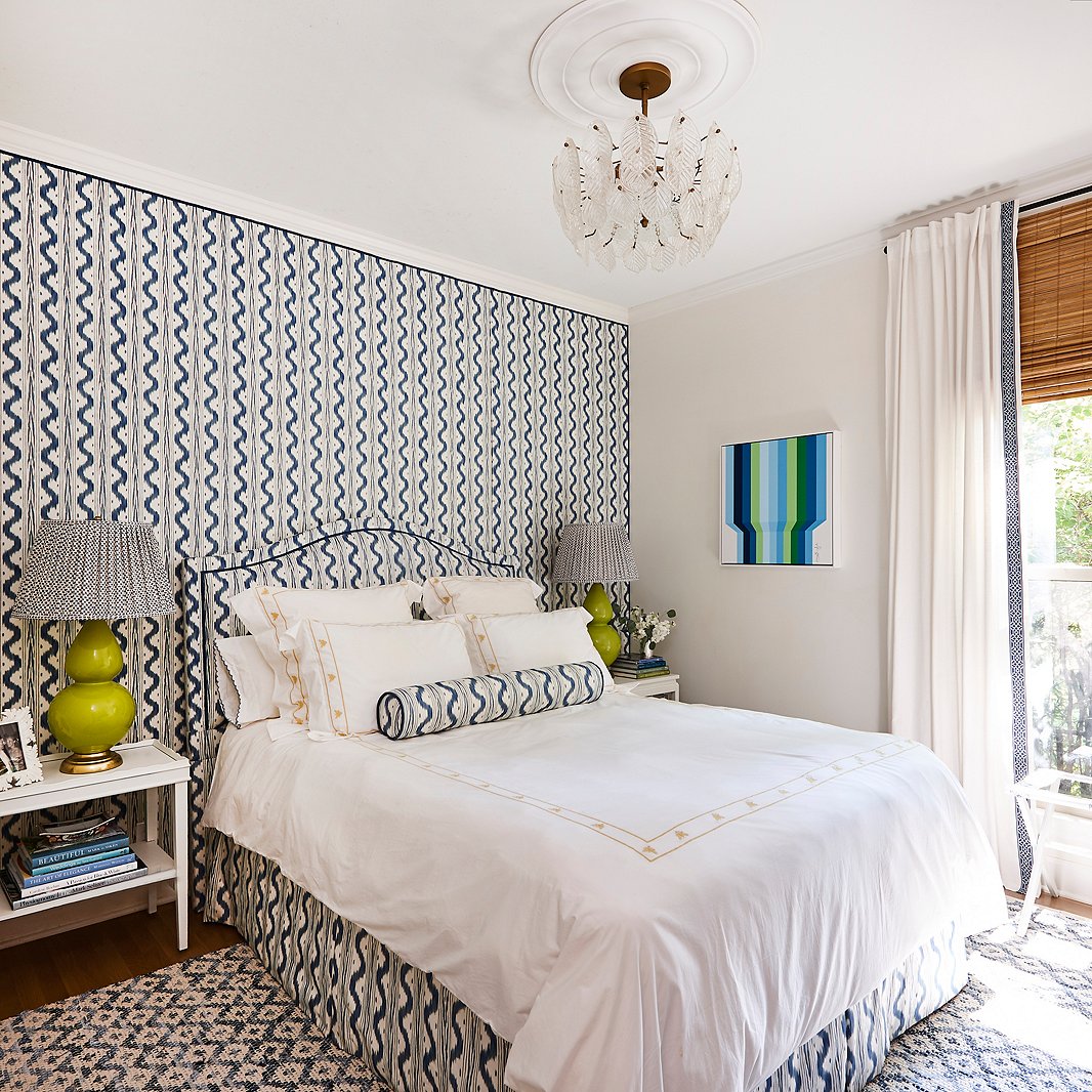 “I wanted to experiment in doing a room in an all-over pattern,” Minnette says, and the guest bedroom made the perfect candidate. Dressed in coordinating blue-and-white prints and accents of apple green, the space is now a dreamy home away from home. A op-art-style painting by Gina Julian adds a bold exclamation point.
