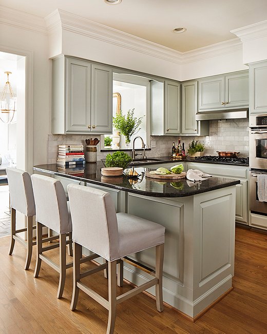 While the kitchen didn’t need a full reno, Minnette did give it a “major facelift,” ditching the faux adobe-textured walls for a crisp coat of white and painting the cabinets a pale sage green. She also replaced an ornate carving above the sink with a simple arch. The Shannon counter stools are similar to those shown above.
