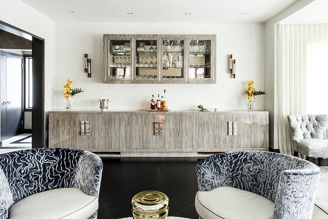 This custom bar is the home’s entertaining command central. A coordinating wall-mounted cabinet provides extra storage and display space for Natalie’s glassware collection.
