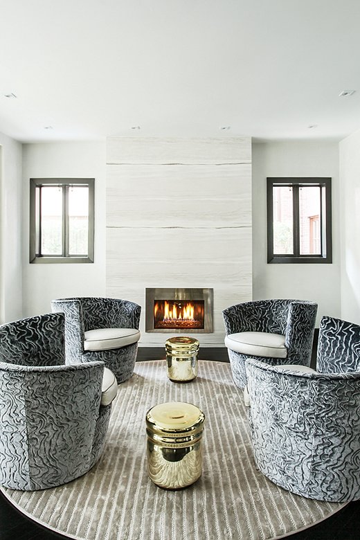 Natalie chose curvilinear pieces for the fireside seating area, including a round rug, metallic stools, and a set of swivel chairs (a favorite of Natalie’s young kids), to counter the strong angles of the rest of the space.
 
