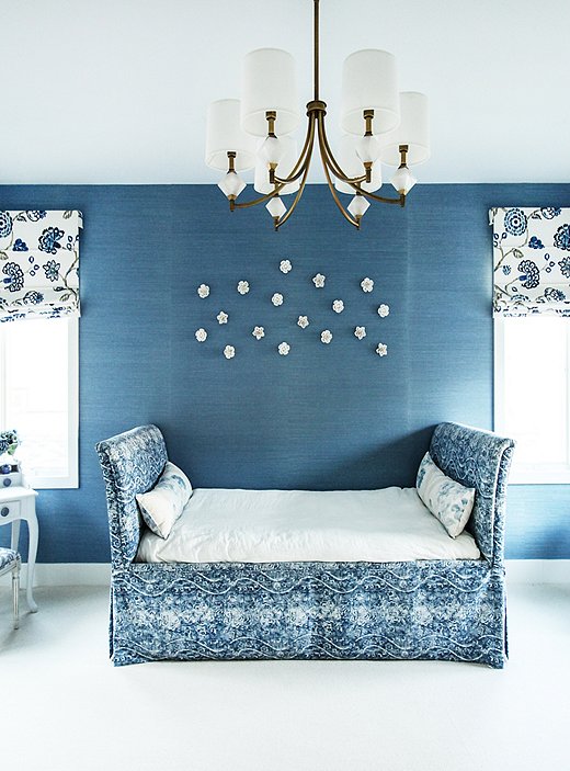 Natalie’s daughter’s bedroom is pretty in blue, not pink. “I didn’t want it to be the typical girly room,” says the designer, who chose a bold blue grass cloth to anchor the monochromatic design scheme. Porcelain flowers add delicate dimension to the wall.
