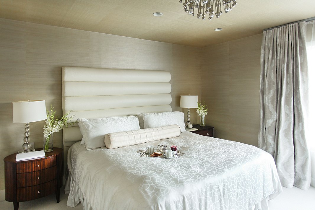“I wanted to create a very soothing, calming space,” says Natalie of the master bedroom. She brought the wallpaper up onto the ceiling to compensate for a lack of height; silky fabrics in a range of pearlescent beige tones enhance the jewel-box effect.
