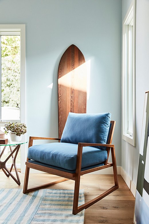 Seating was another of Minnie’s must-haves for the master bedroom, so the design team added a comfy chair and a glass-top side table just off the door to the back garden. The patchwork-stripe rug is by Ralph Lauren Home, and the wooden surfboard is Minnie’s own.
