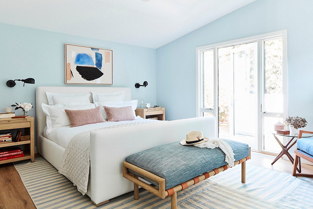 “I always love to have a bench at the end of my bed,” says Minnie, and this leather-strapped version by Community provides the perfect spot to toss decorative bed pillows or a robe while adding a touch of color and organic texture to the room. The upholstered bed, also by Community, meets Minnie’s criteria of a “statement bed” while aligning with the softly streamlined feel of the rest of the home.

