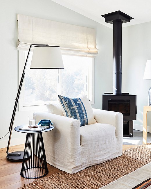 One Kings Lane partnered with California-based furniture maker Community to source some special upholstery pieces for the home, including the living room sofa, club chair, and custom daybed, all handcrafted in nearby Los Angeles. The modern black woodstove ties into the metal detailing elsewhere in the space, including the dramatic floor lamp and the geometric side table.

