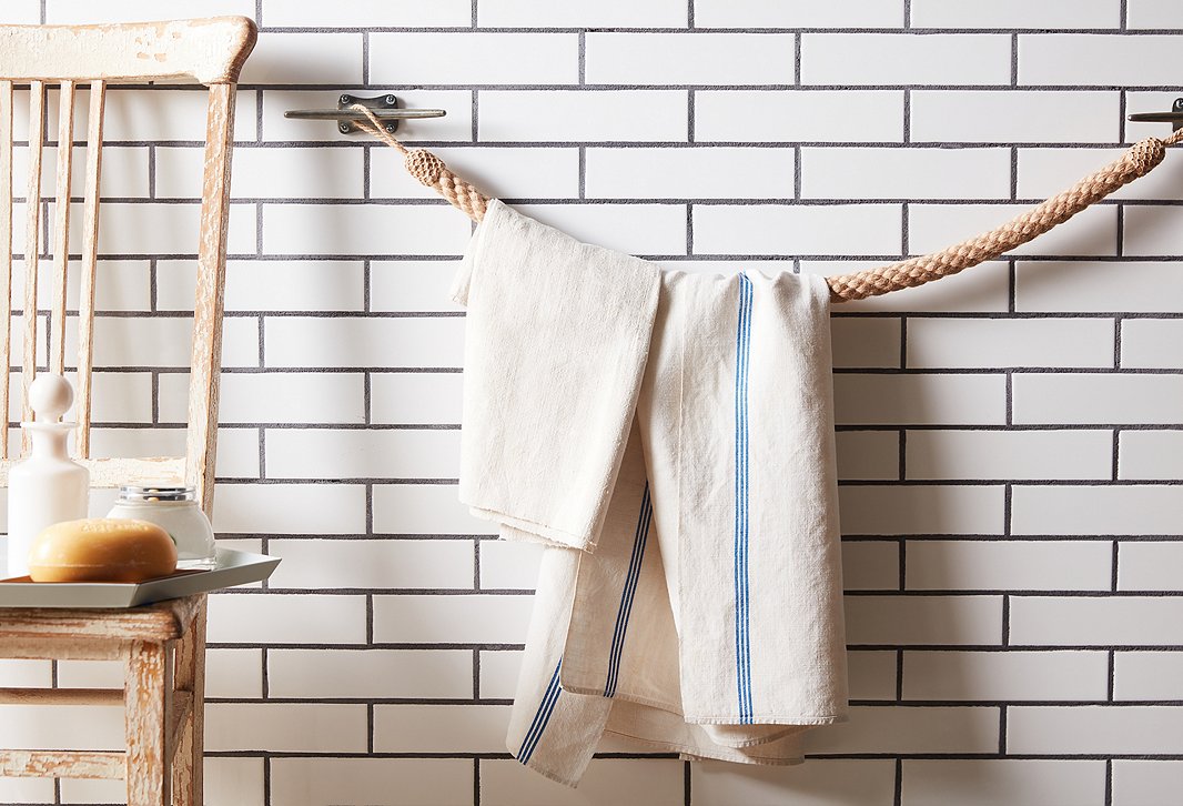 Looped around a set of boat cleats, a rope tieback becomes a nautical-chic towel bar.
