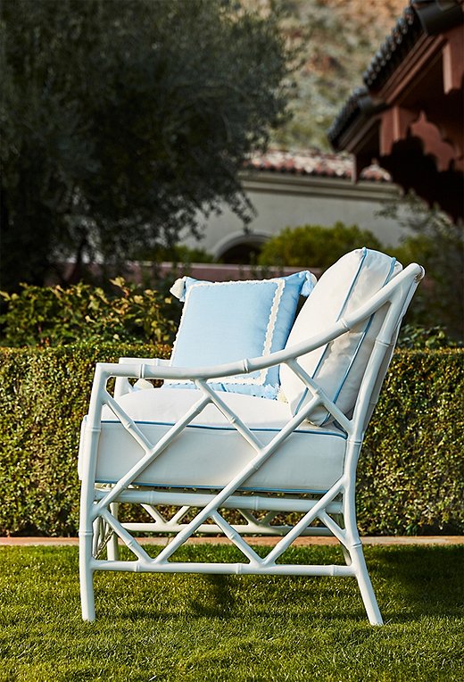 The Kit Lounge Chair (here in white) boasts a striking fretwork frame. We love it topped with the tasseled Liz Outdoor Pillow.
