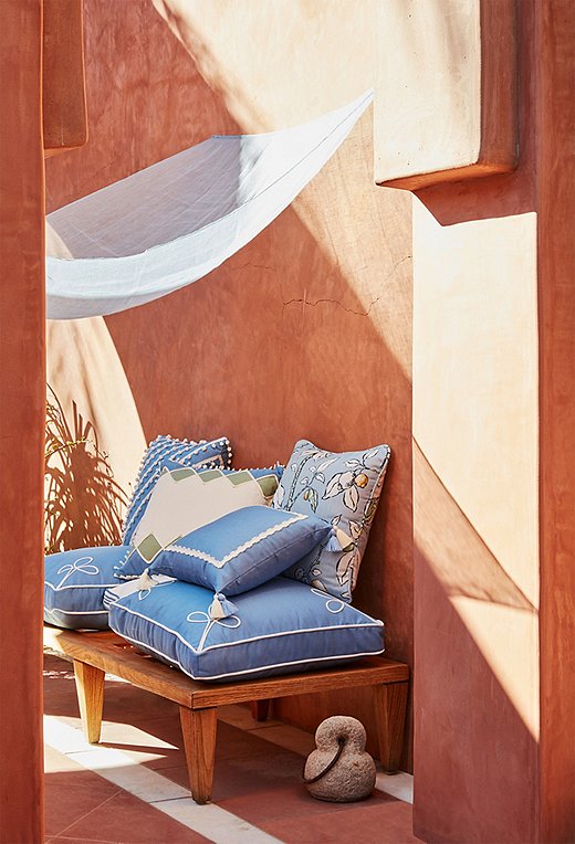 Atop two Kit Outdoor Box Pillows rest an array of outdoor throw pillows (Maddie, Milly, Liz , and Kit) from Celerie’s collection for One Kings Lane.
