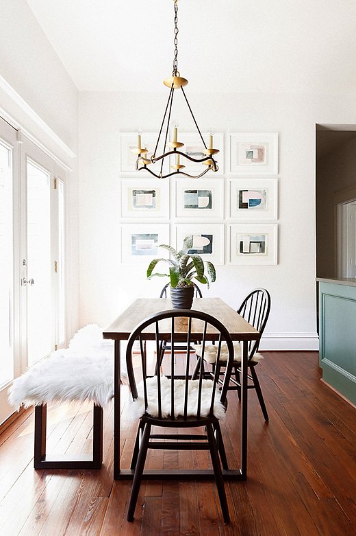 In the breakfast room, Elizabeth paired timeless Windsor chairs with a modern table and bench, topped with a sheepskin for coziness. Visual Comfort’s Choros chandelier draws the eye up, emphasizing the high vaulted ceiling, while the artwork picks up on the color of the adjacent kitchen cabinets.
