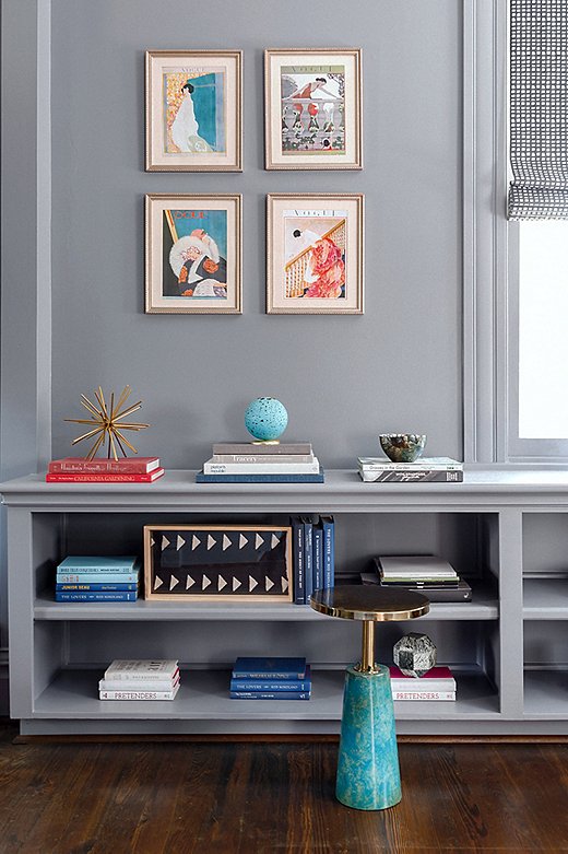 Stacks of books give the shelves a cool color-block effect. The framed illustrations above are in keeping with the home’s vintage-meets-modern vibe.
 
