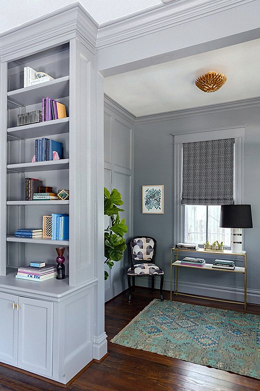 The Roman shades in the entryway and library are also in Elizabeth’s Color Grid Print fabric. “I love how they pop against the wall color,” she says. “We wanted the textiles to be rich and had fun with mixing textures.” A kilim rug adds even more pattern, and a gold flush-mount fixture lends a touch of glamour.
