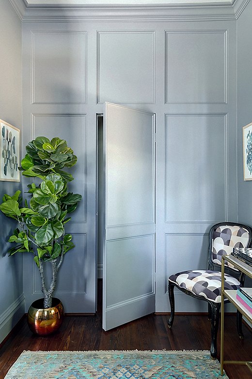The entryway’s far wall boasts beautiful paneled molding—and a cleverly concealed powder-room door. A Louis-style accent chair updated with a geometric print provides a spot to drop bags or to perch while putting on shoes.
