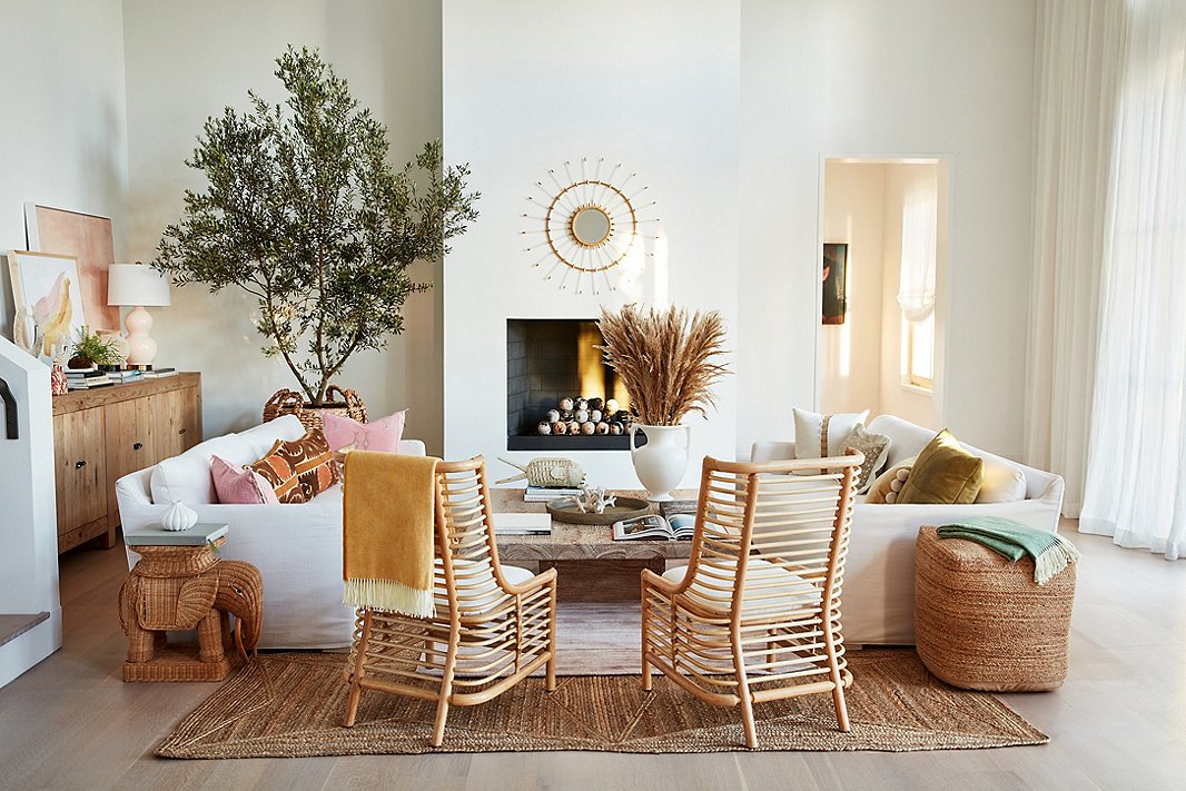 Wingback chairs made of rattan or bamboo give an unexpected airiness to the stately silhouette. Find similar sofas here and the jute pouf here.
