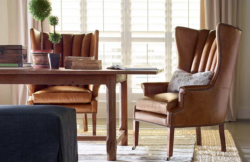 Leather chairs like these channeled wingbacks will gain a warm patina over time. The chairs are also available in black velvet; find the dining table here.
