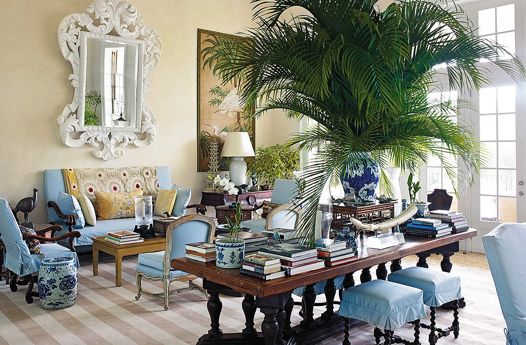 “If you have formal furniture and decide you would like a more tropical look for it, try covering the pieces in inexpensive cotton canvas or duck,” writes Bunny, pointing out the sky-blue slipcovers she used to ease up the sofas and chairs in the high-ceilinged island living room.
