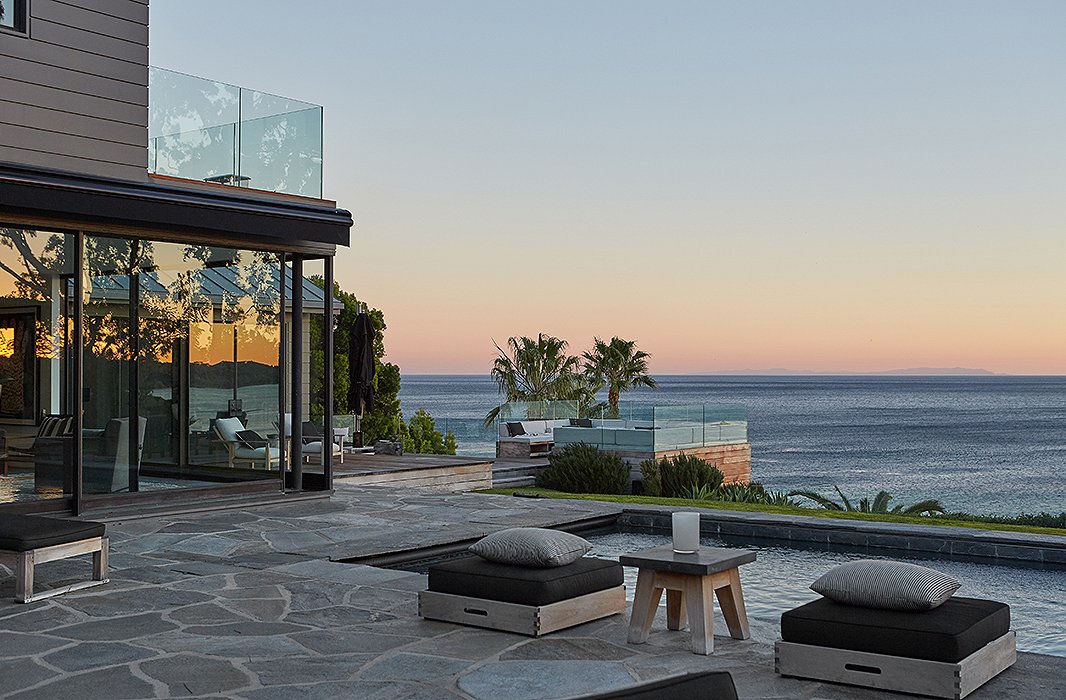 A saltwater swimming pool and a banquette-ringed fire pit overlook the Pacific Ocean.
