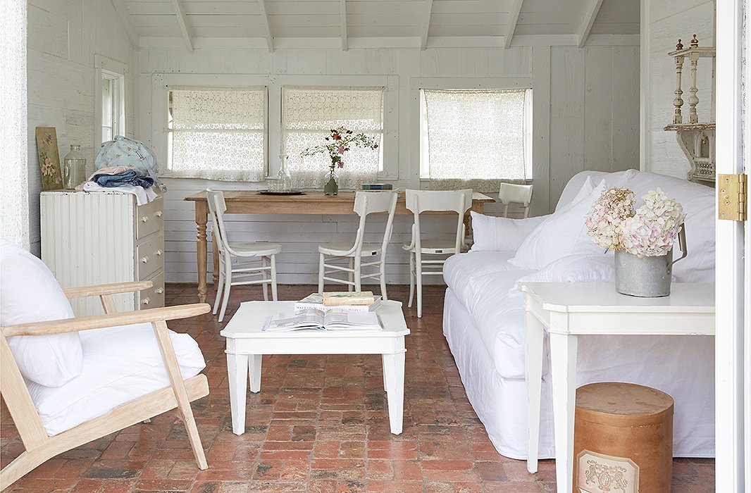 The living room at Blue Bonnet Barn, one of five guest cottages at The Prairie. The original wood-paneled walls and brick floors lend the space a welcoming, homespun vibe.
