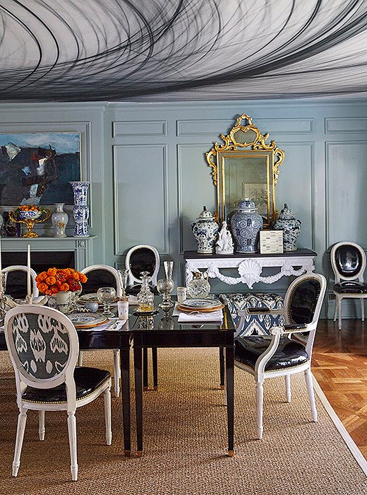 In her Dallas dining room, Michelle upholstered just the backs of her dining chairs in a striking ikat fabric. On the ceiling, patterned wallpaper (actually a detail of a photograph blown up to room size) adds an unexpected moment of drama.
