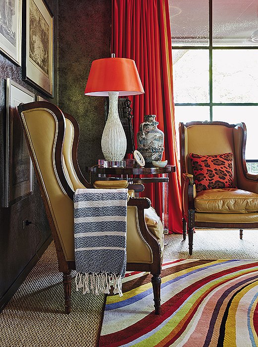 The TV room of Michelle’s Dallas home is both cozy and calming in rich caramel and red tones. Touches of pattern in the pillow, the throw, and the rug are just enough to enliven the space’s solid tones.
