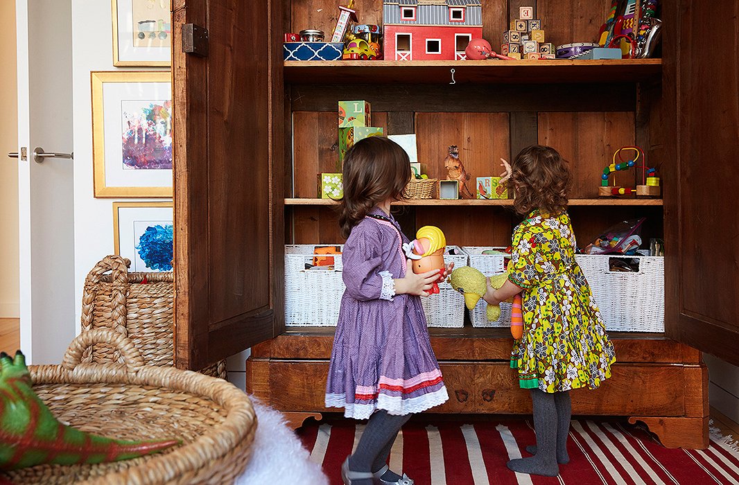 A row of baskets on the bottom shelf keeps favorite toys at toddler height. And the armoire has been fun for the grown-ups too: “Rassi and I are both organizing freaks, so it’s really nice,” Zanna says. “The label-maker came out.”
