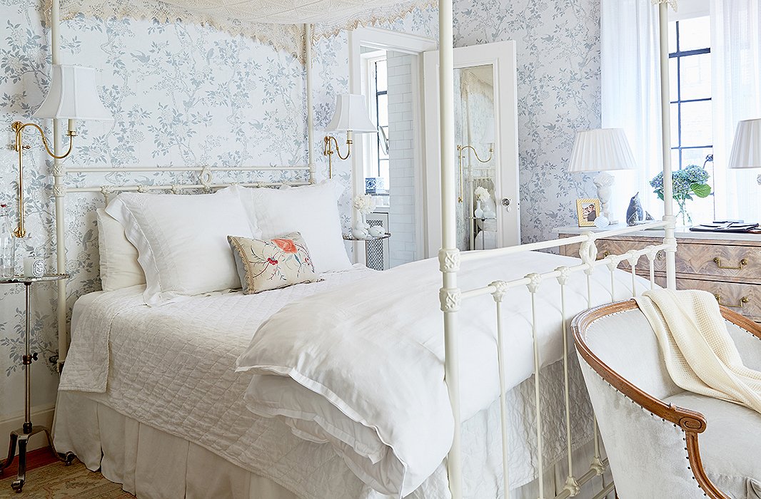 The pale-blue floral wallpaper sets a quiet mood in this cottage-style bedroom. Photo by Tony Vu.
