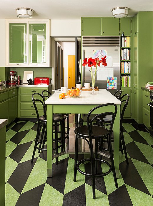 Ensconced in Benjamin Moore’s Courtyard Green, the kitchen is as stylish as it is practical. The glass cabinet doors were reverse-painted to keep messy shelves out of sight but still reflect incoming sunlight. The linoleum floor provides a pop of pattern, feels good under foot, and is easy to clean. Kate’s favorite element, though, is the marble island: “I like the way it looks as it stains and gets worn… it acquires a kind of personality.” 
