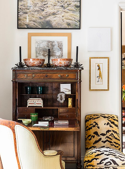 A birthday gift from Kate’s mother, a slipper chair covered in tiger-print velvet offsets a secretary filled with small treasures. 
