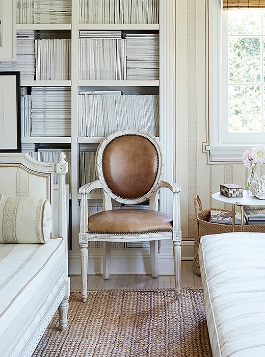 Leather upholstery and a crisp white finish add a modern touch to a round-back Louis XVI armchair. Ribbon-twist carvings encircle the back and the seat. Photo by Joe Schmelzer.
