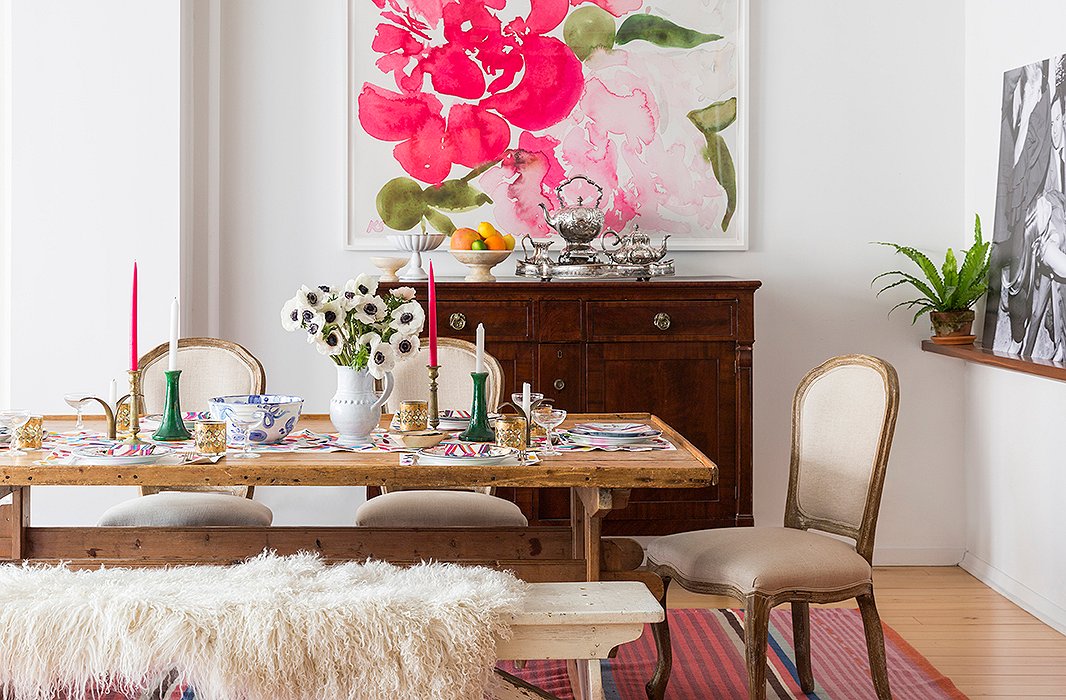 In the dining room, a bench bought at an estate sale in Cape Cod was one of Kate and Chris’s first joint furniture purchases. “We actually bought it for his apartment before we lived together, and then the table came along once we were married,” she recalls. Painted in a shade just shy of pure white, it complements the Scandinavian scrubbed-pine table and the walnut sideboard. “It’s been with us in a lot of different apartments and has stored a lot more than just the family silver,” Kate laughs. 