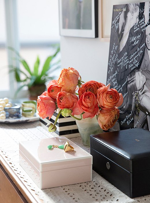 A monogrammed leather jewelry box by T. Anthony sits atop a dresser in the master bedroom. The wall behind is dedicated to family photographs displayed in silver frames given as wedding gifts, “that’s our little family shrine area,” she says. 