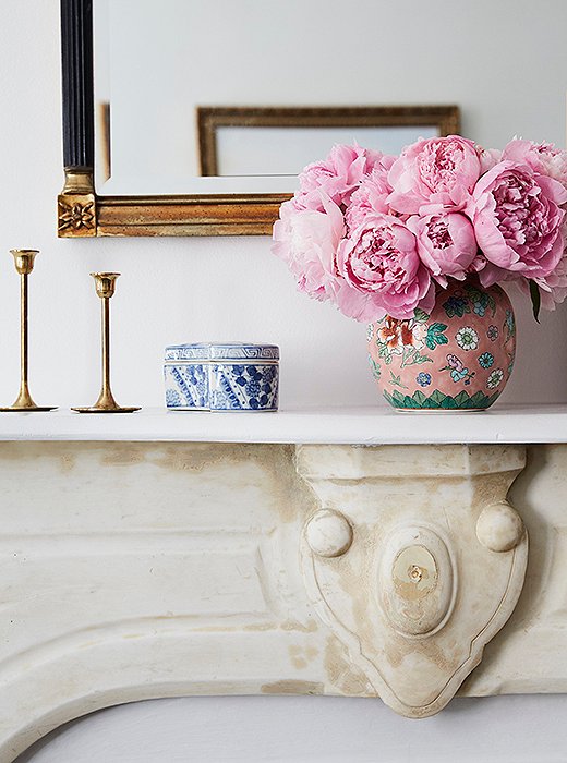 A collection of artful accents, including brass candlesticks and chinoiserie ceramics, adorns the mantel. Amy fell hard for this vintage mirror, with its columnlike details and faux-painted marble finish.
