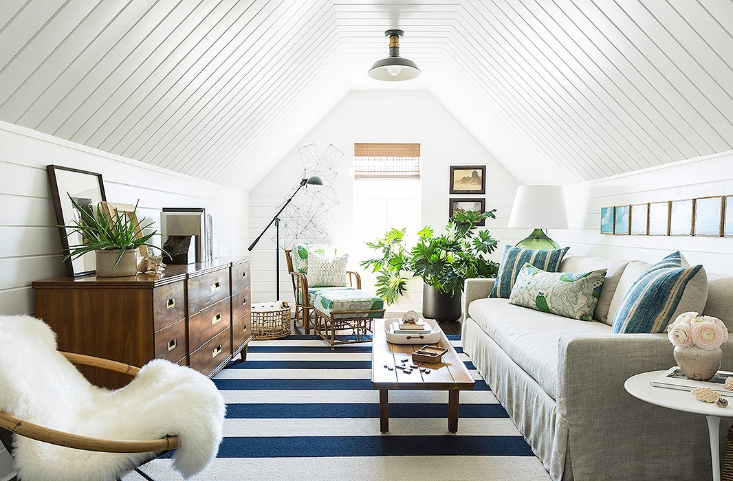 Just off the master bedroom, the attic living space brings together Matthew’s love of blue and white and his husband’s love of greenery. “We really wanted to finish off the attic space and make it like our own private living room,” says Matthew. “It’s funny, coming from New York, where space is a luxury: It’s one of the things we enjoy about the home, but even in that spaciousness my favorite room is probably the smallest room in the home.”
