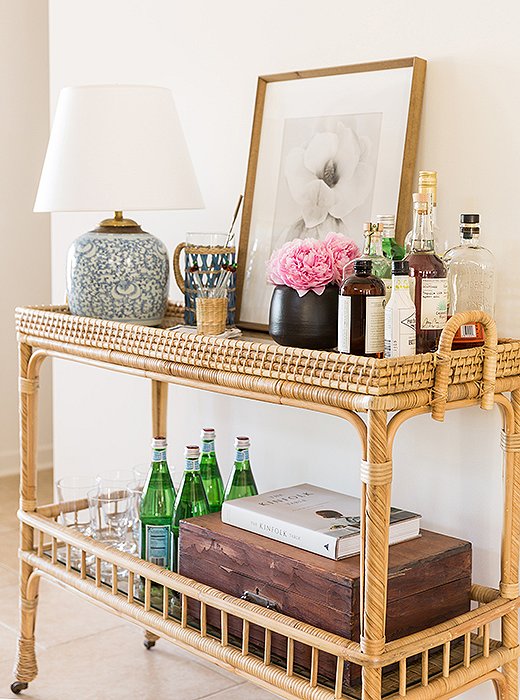 The bar is always self-serve, says Matthew, who fancies sidecars and, in summer, mojitos. The bar cart is enlivened with a repurposed vintage ginger-jar lamp and a print by Ron van Dongen.
