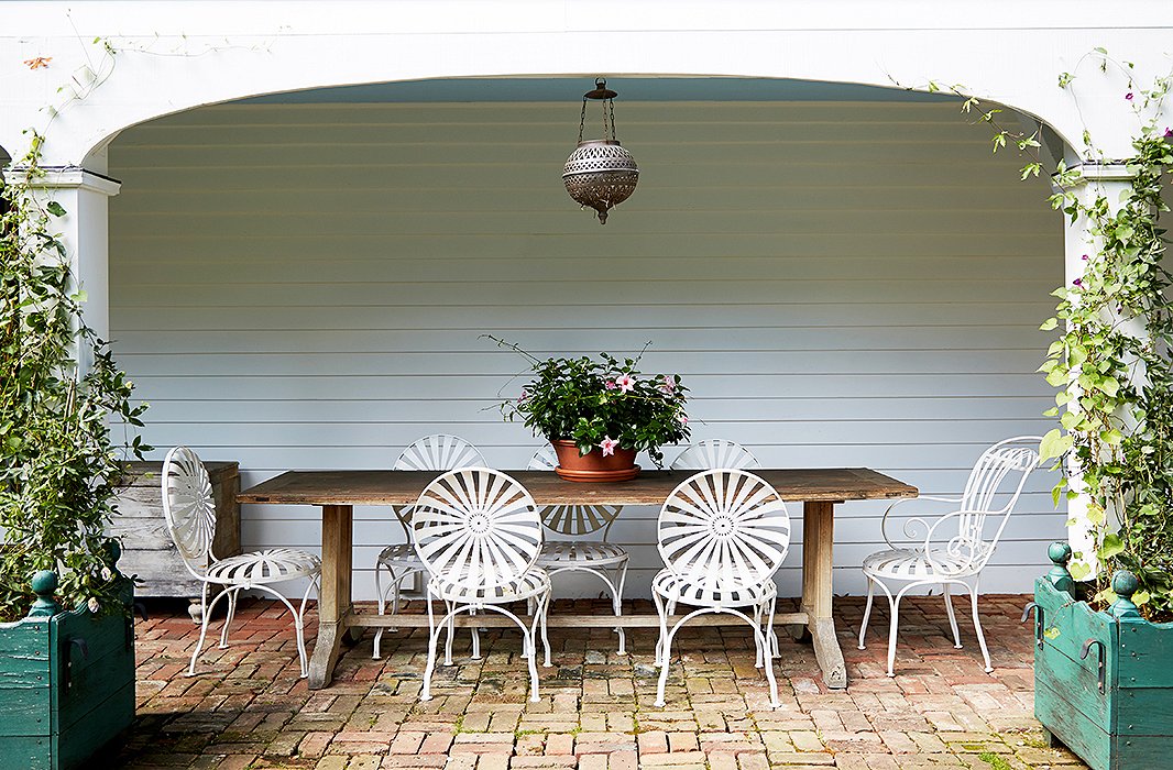 The multiple porches surrounding Bunny’s country home recall her childhood days. She spent many humid afternoons with friends and family lounging on porches. This arched loggia was once a spot for carriages.
